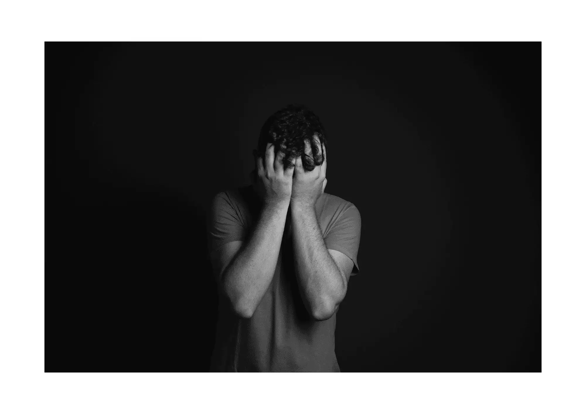 a man with his hands over his face