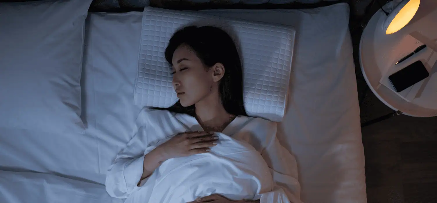 a woman lying in bed with her eyes closed